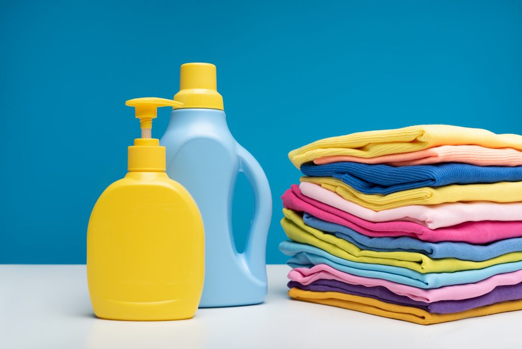 Canva Heap of clean clothes folded near detergents